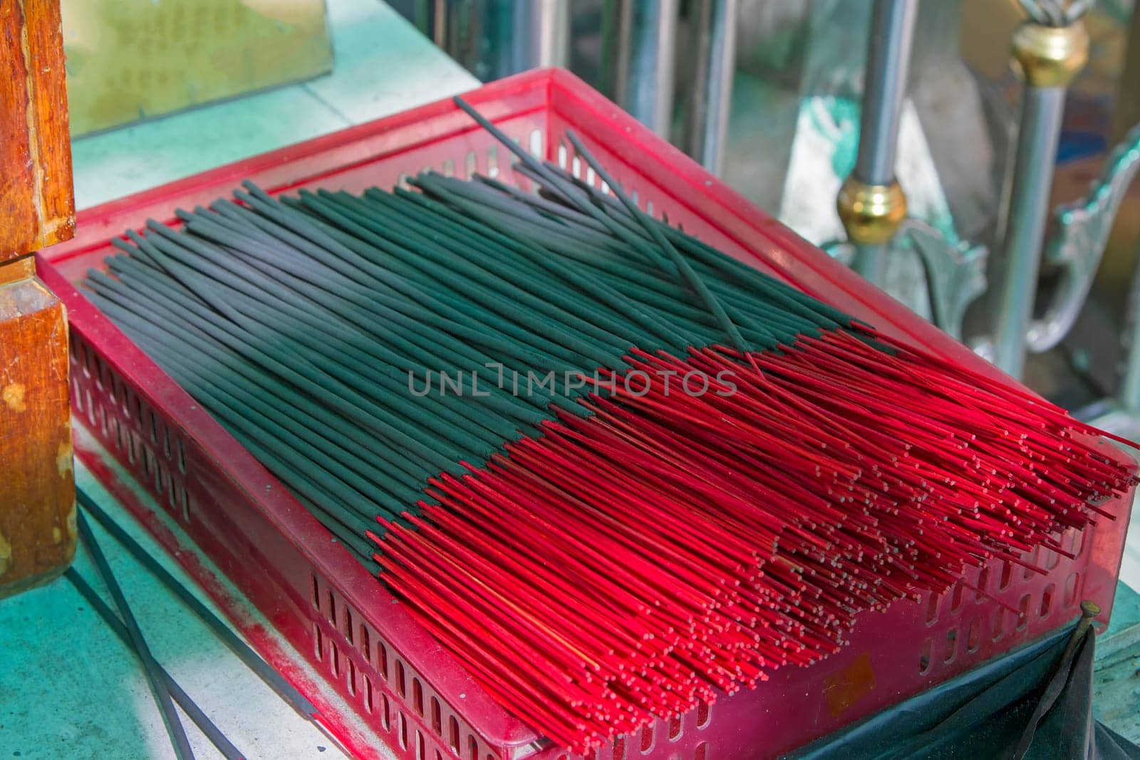 Many black incense sticks in a red basket.