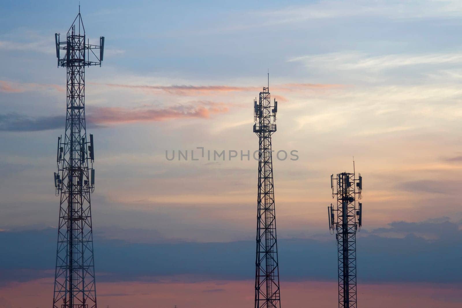 Three mobile phone communication tower transmission  signal  leash in evening sky