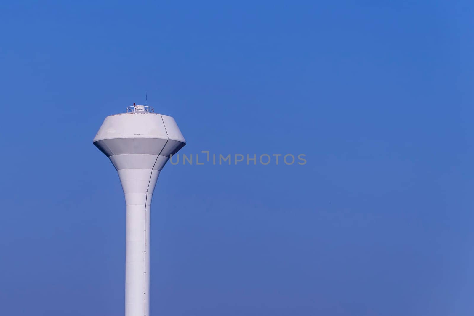Large white water tank with blue sky background