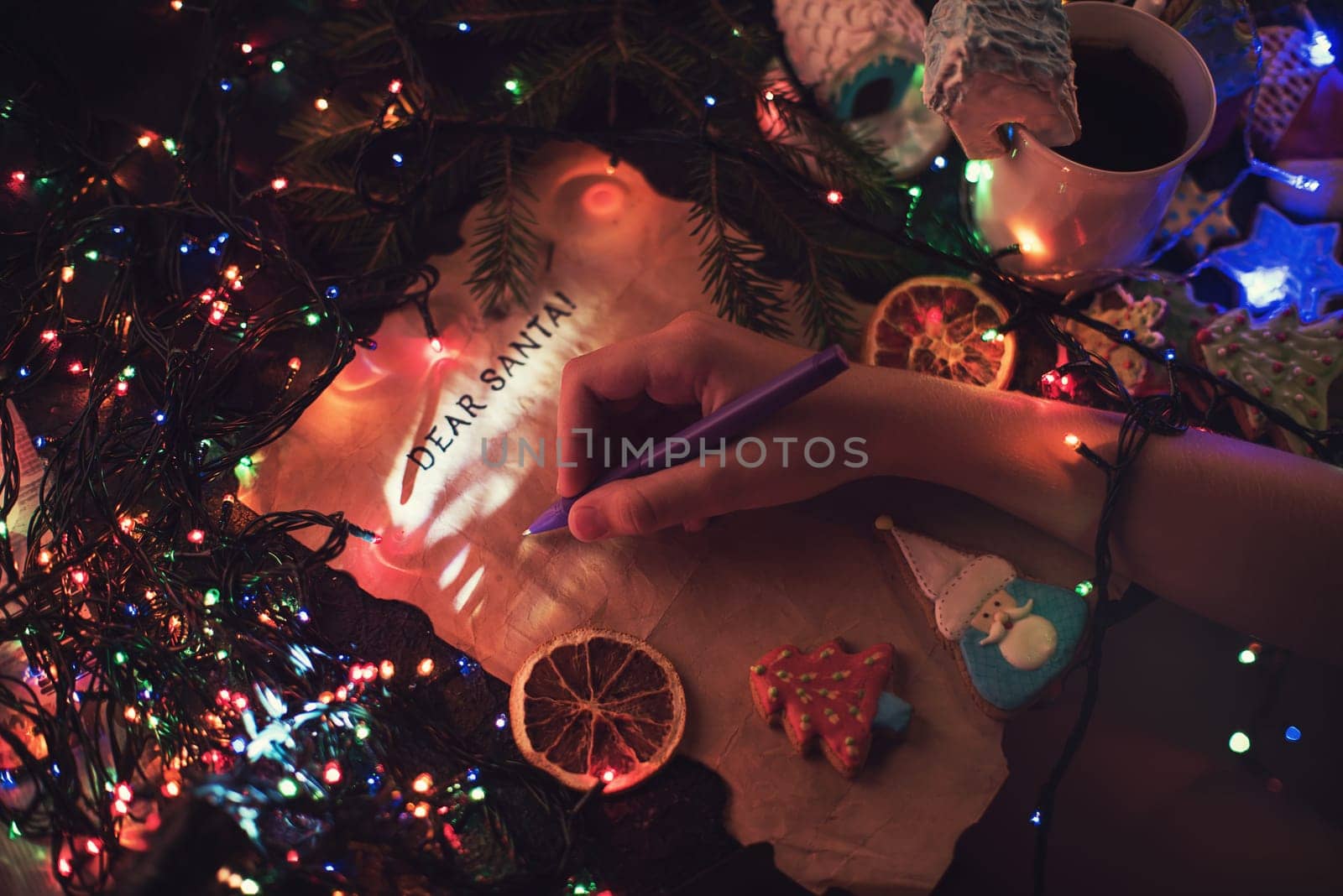 Boy's hand closeup, writing a letter to Santa, cristmas background