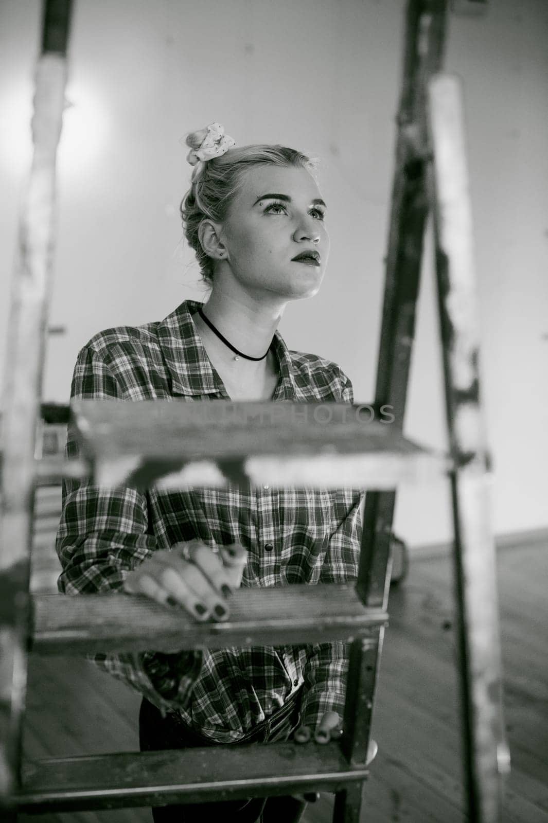 girl and construction ladder. studio shot of a young woman with a construction ladder in the room
