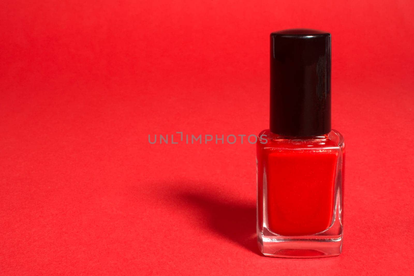 Red nail polish on the red background.