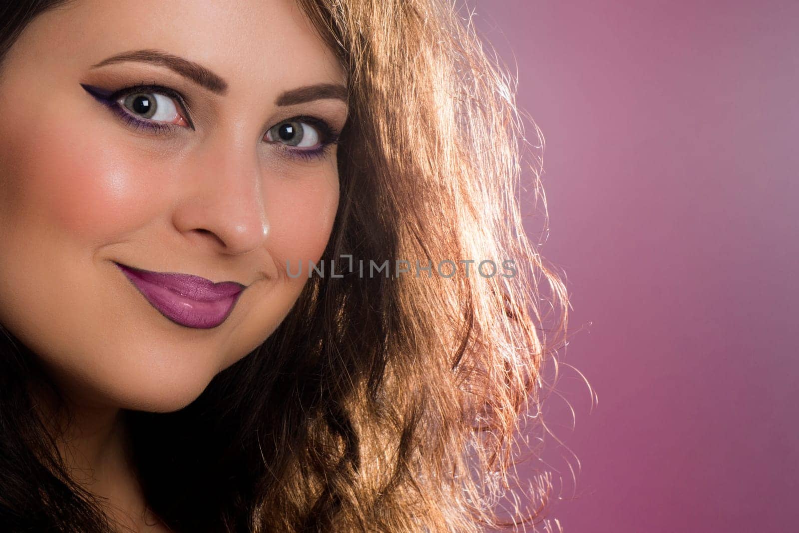 Smiling woman with perfect purple lipstick on mouth.