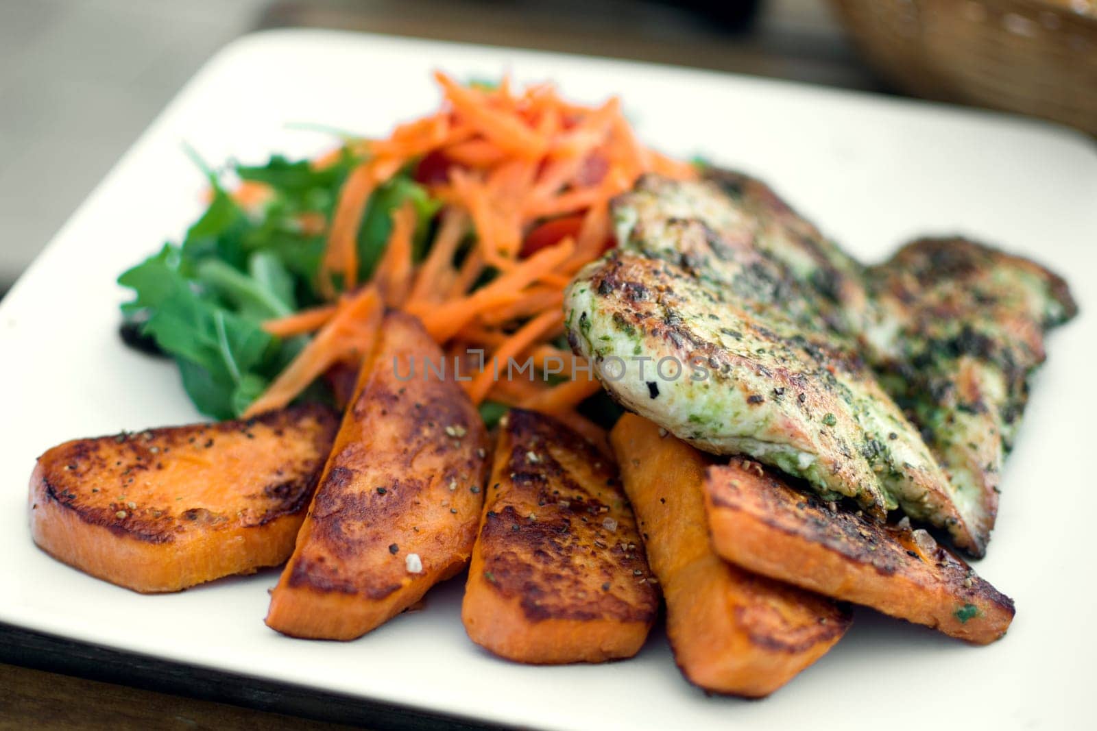 Chicken meat with sweet potato is served on white plate.