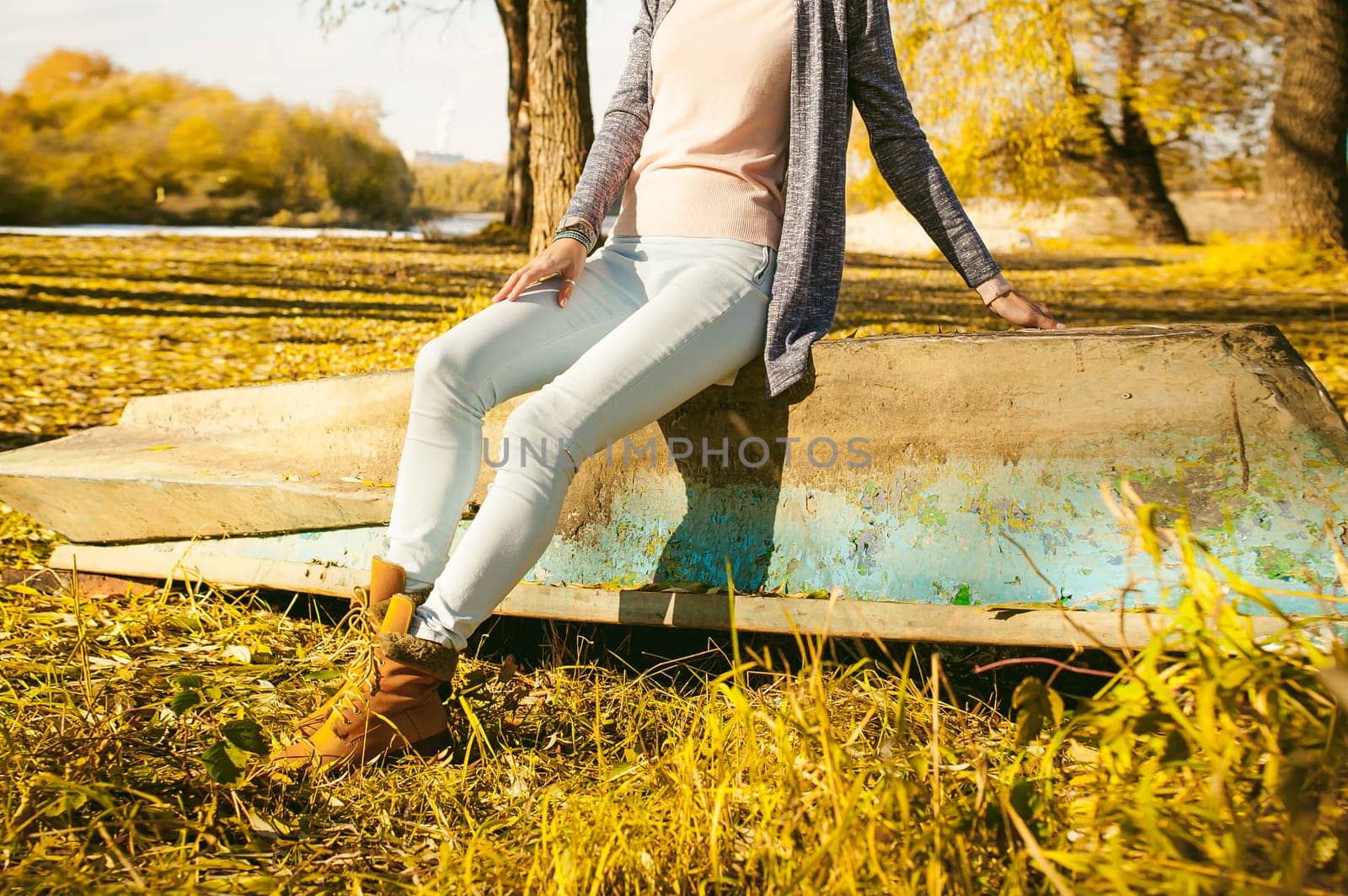 Slim girl in blue jeans, a jacket and brown boots