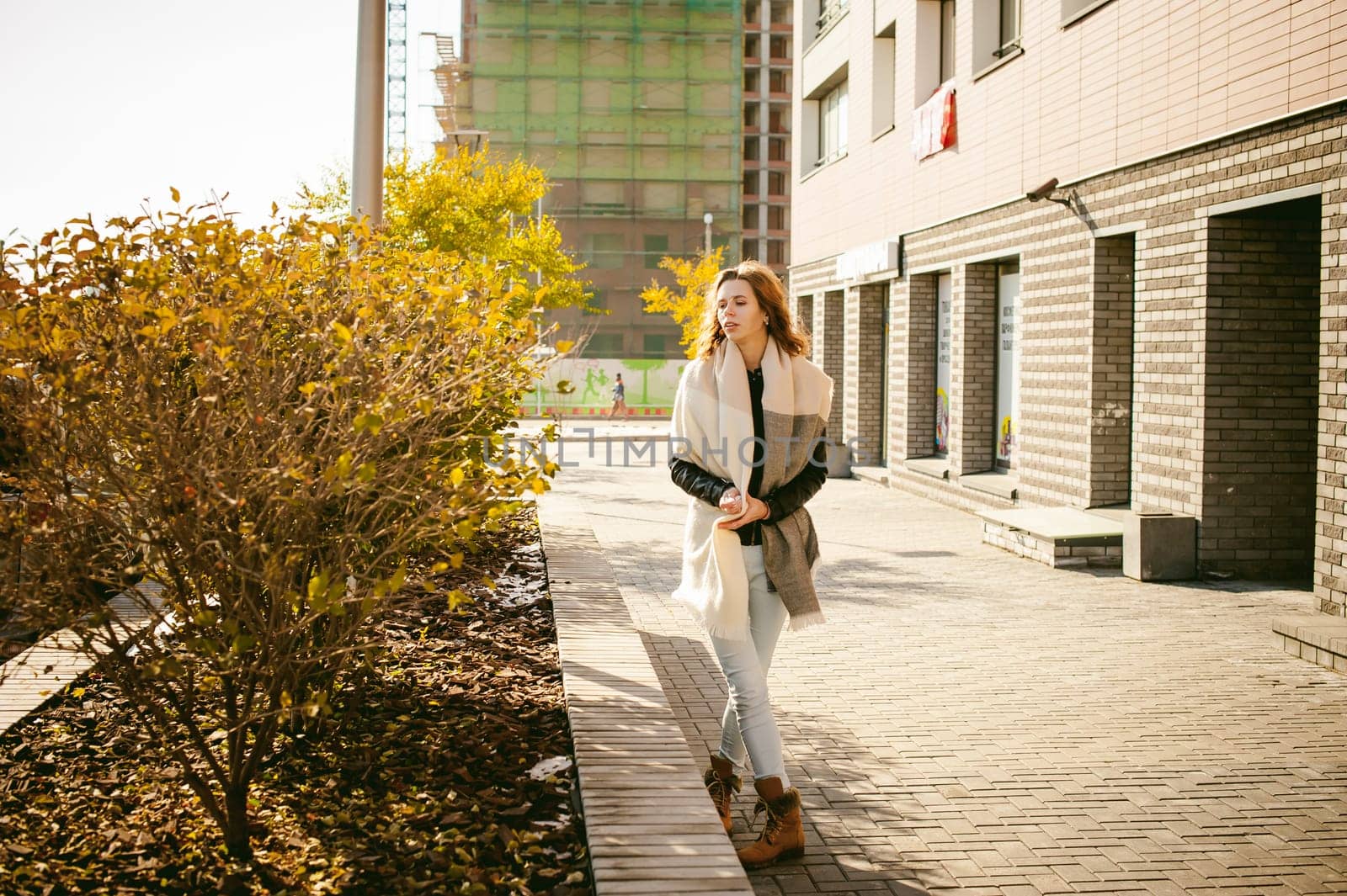 Portrait of young woman walking outdoors on warm autumn afternoon.