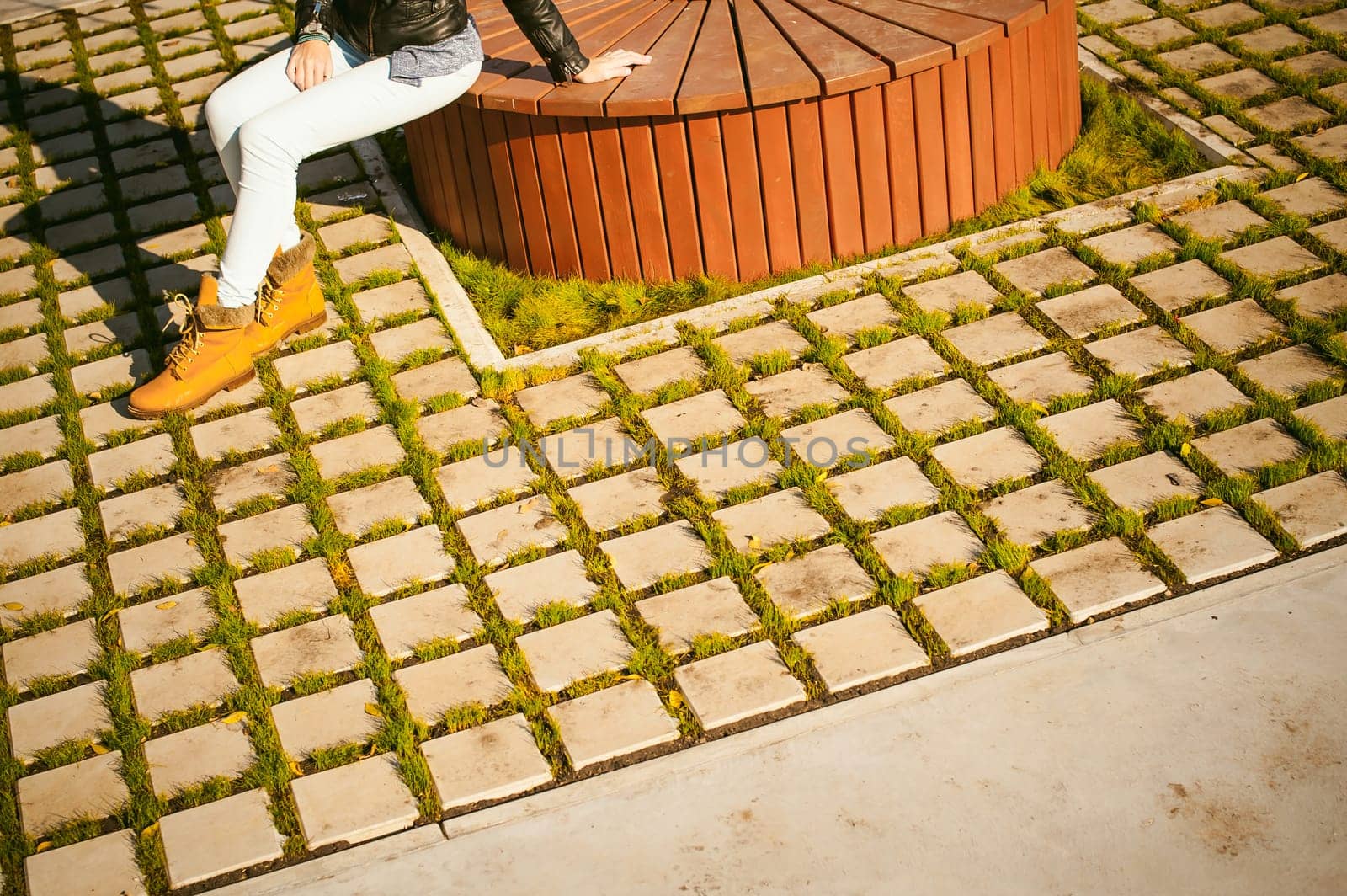 Portrait of young woman walking outdoors on warm autumn afternoon. Sitting resting