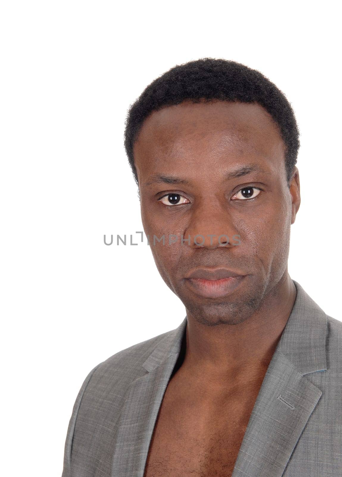 A handsome African American man standing, wearing a jacket and no.shirt, looking serious, isolated for white background.