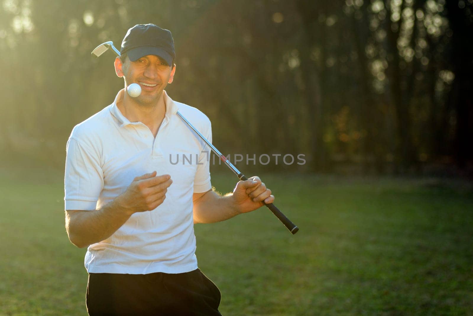 Portrait of cheerful golf player with putter and ball.