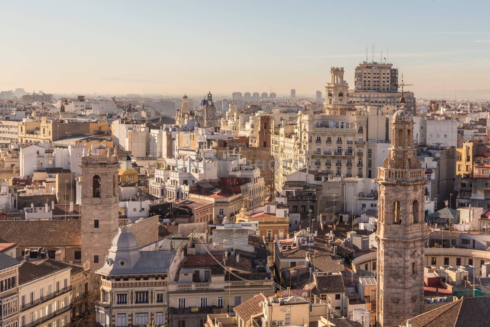 Aerial view of cityscape view on the old residential buildings with church tower in Valencia city during the sunny day in Spain.