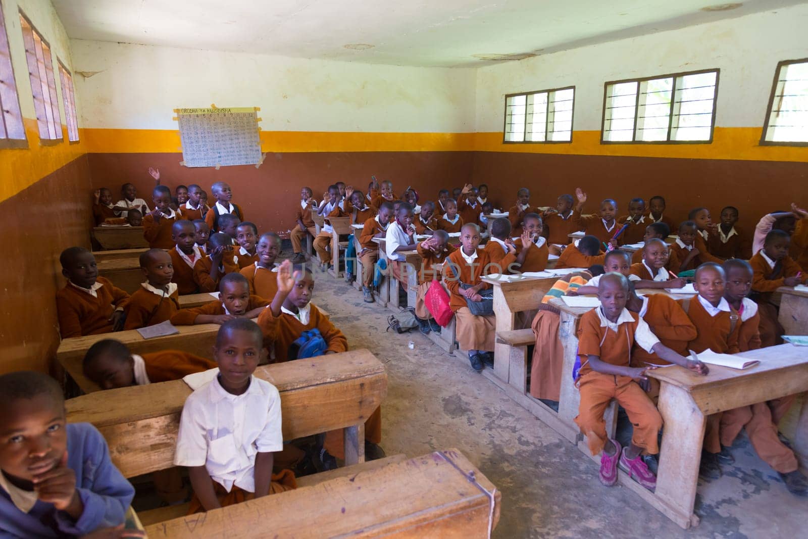 Arusha, Tanzania- Jan 26, 2015: Children in uniforms in elementary school classroom sitting behind desks listetning to teacher on January the 26th, rural area near Arusha, Tanzania, Africa.