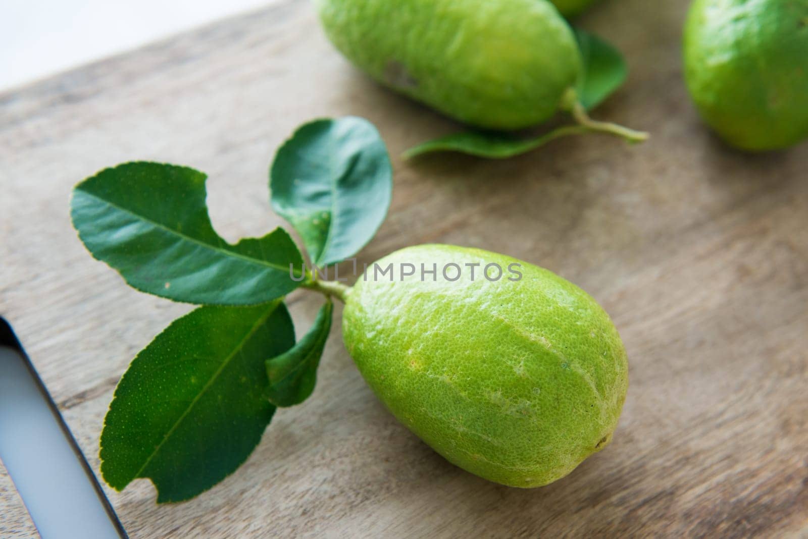 Pesticide free fresh organic lemons with leaves on wooden table background.