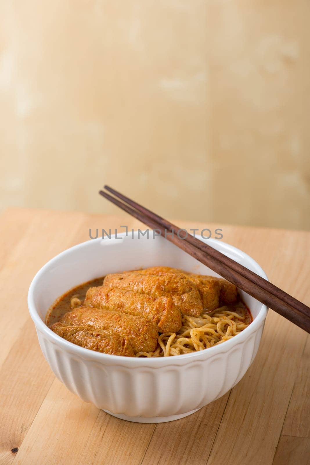 Hot and spicy Malaysian curry noodle with chopsticks on table.