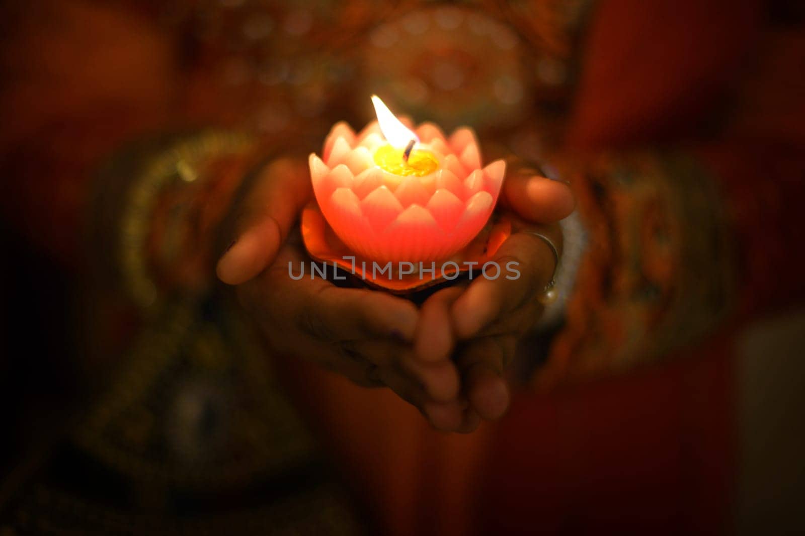 Indian female hands holding Diwali oil lamp.
