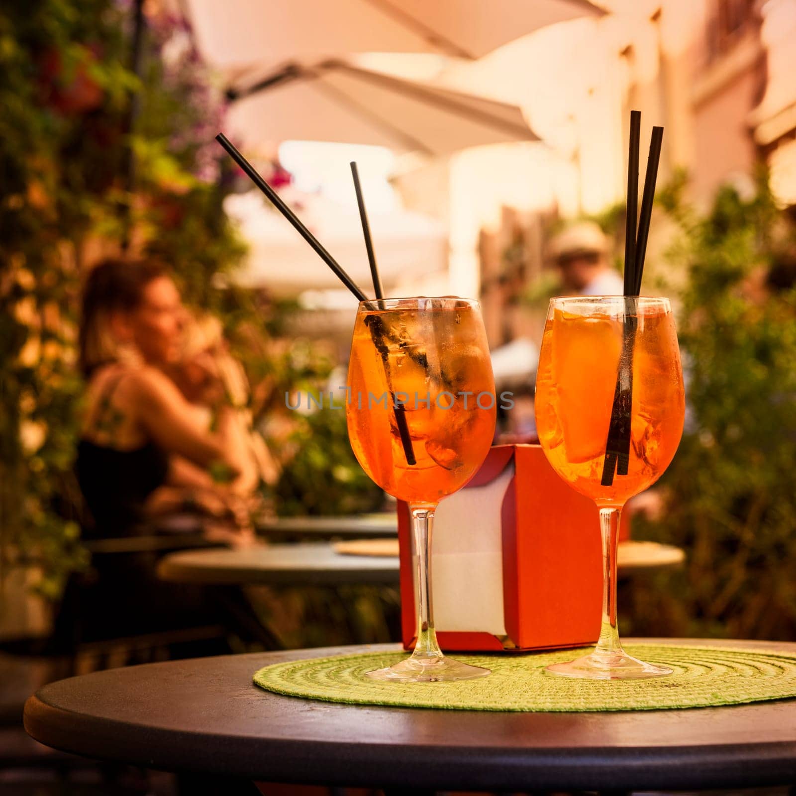 Aperol Spritz Cocktail. Alcoholic beverage based on table with ice cubes and oranges.