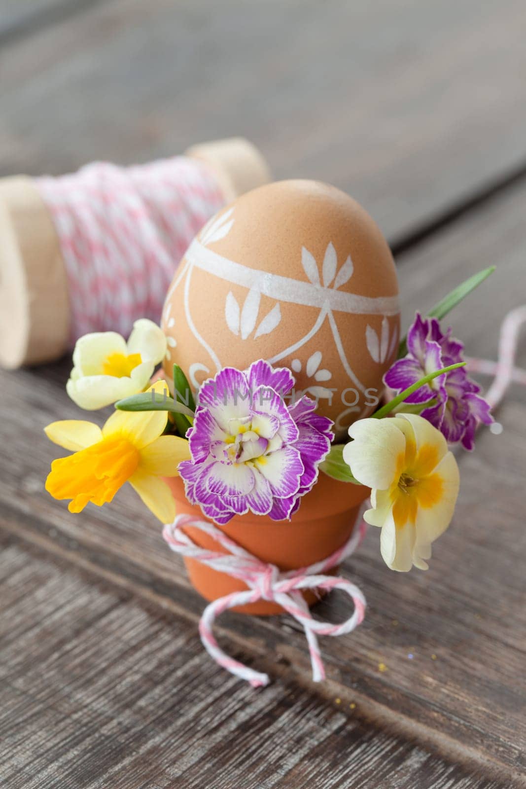 Painted Easter egg with fresh colorful blues in a small terracotta pot