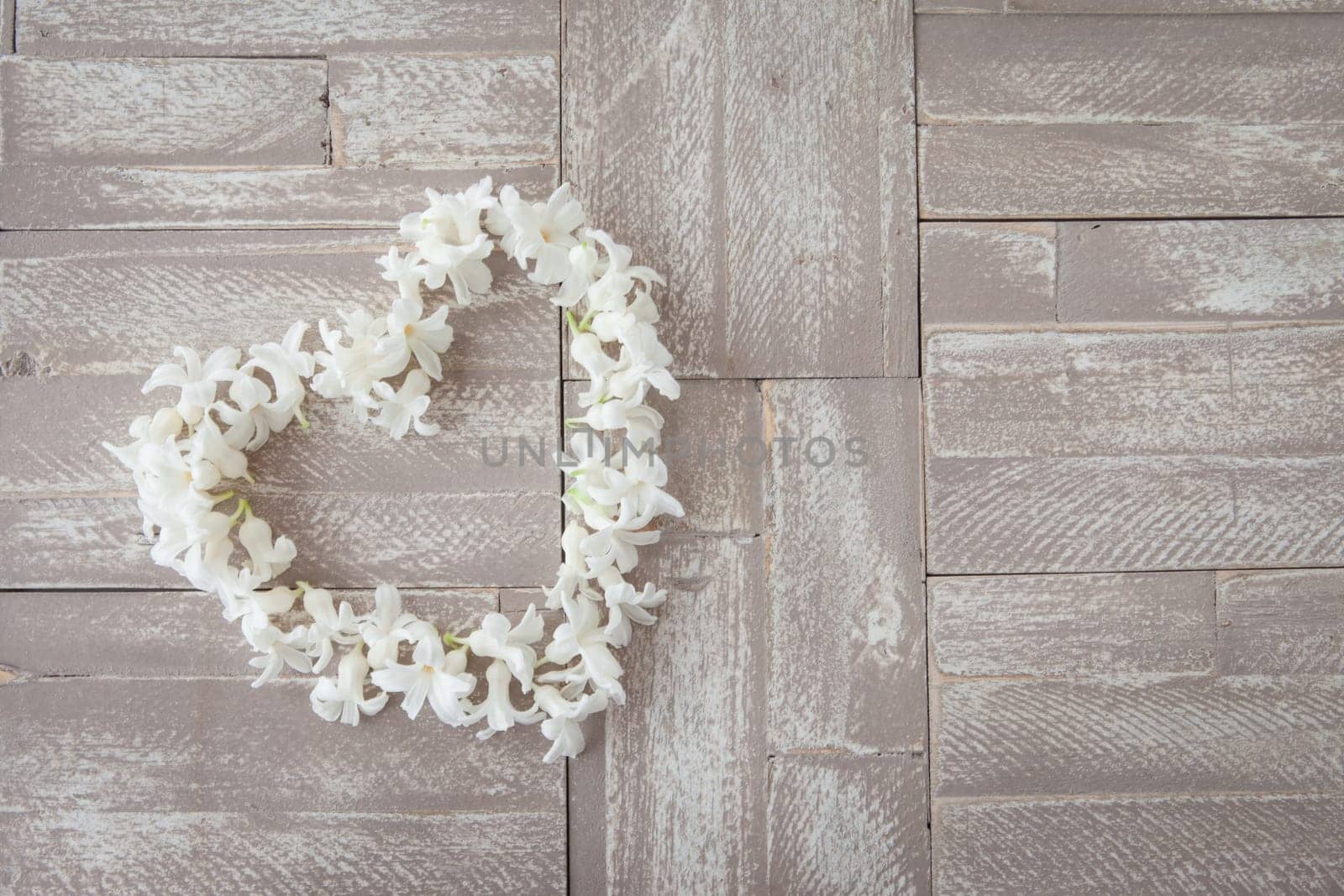 Heart of white blues on background of wood