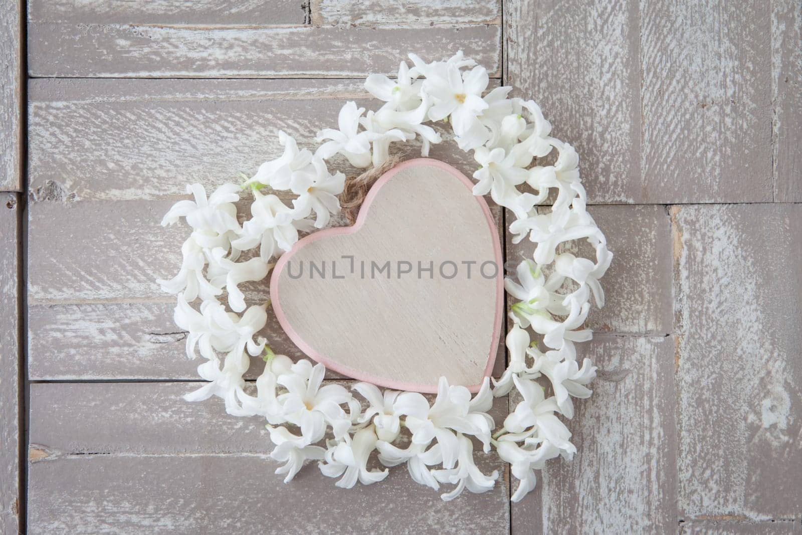 Heart of white blues on background of wood