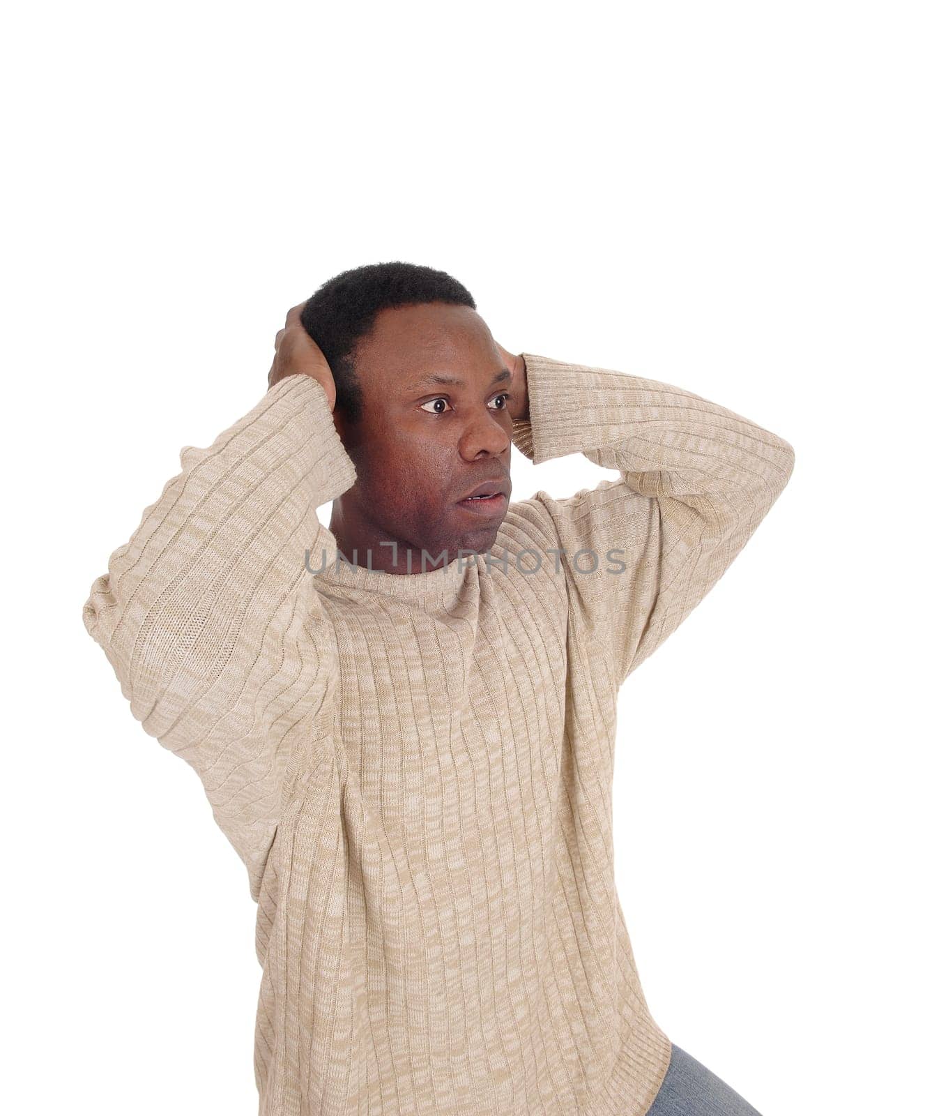 A young African American man looking horrified and scary with his.hands on his head and big eyes, isolated for white background.