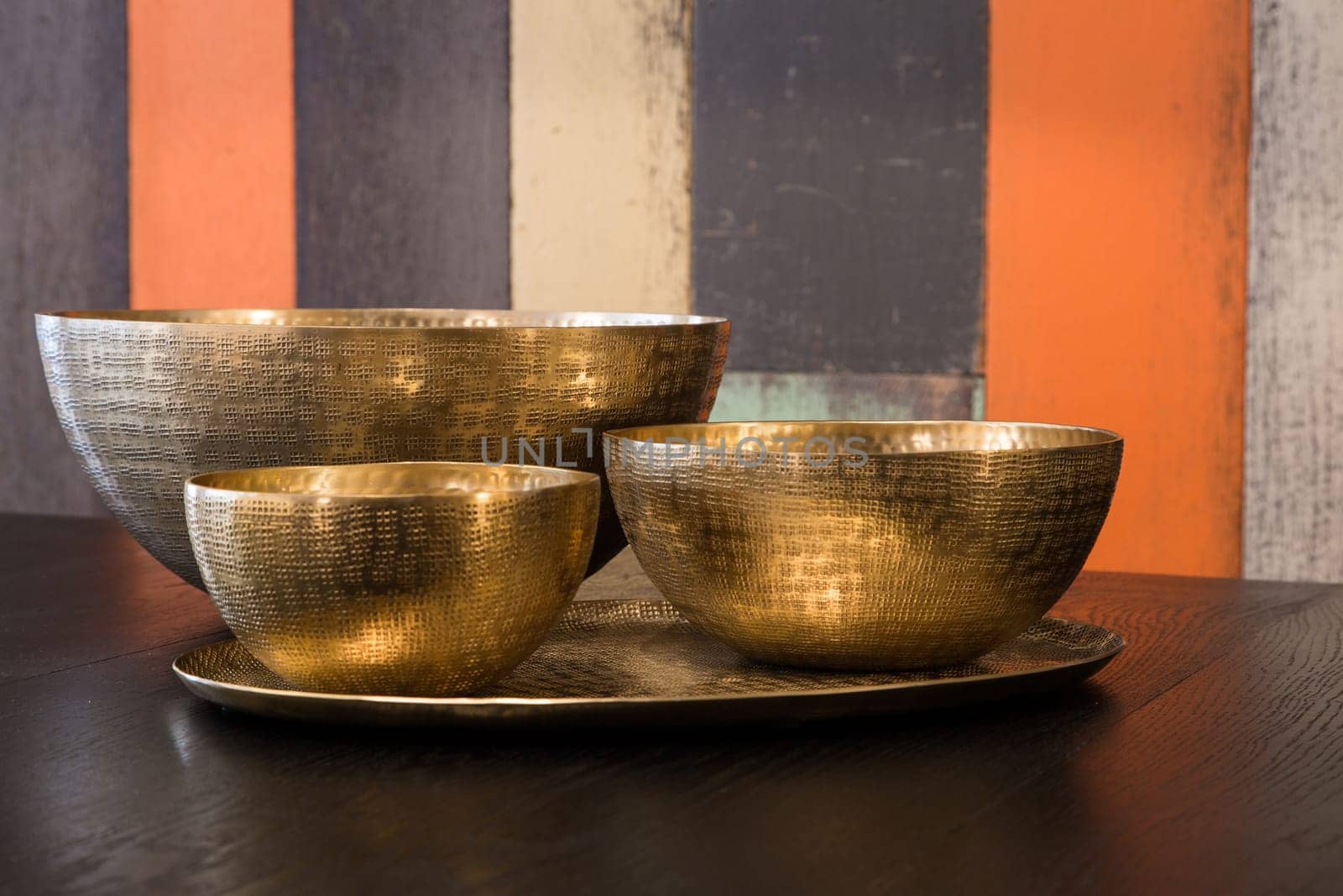 Three empty decorated metal bowls on a table