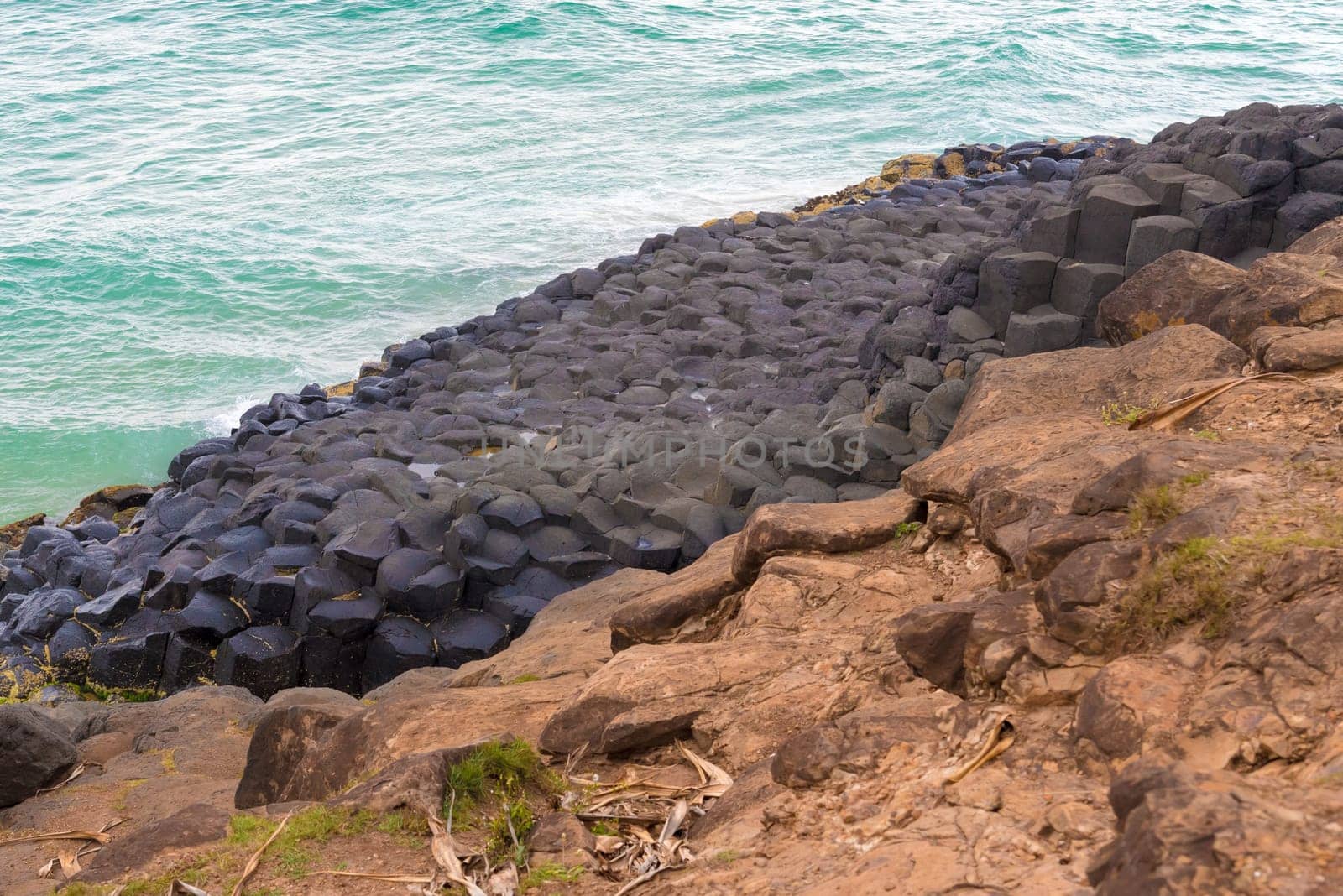 Crescent shaped hexagonal rock formations at Fingal Head, Australia