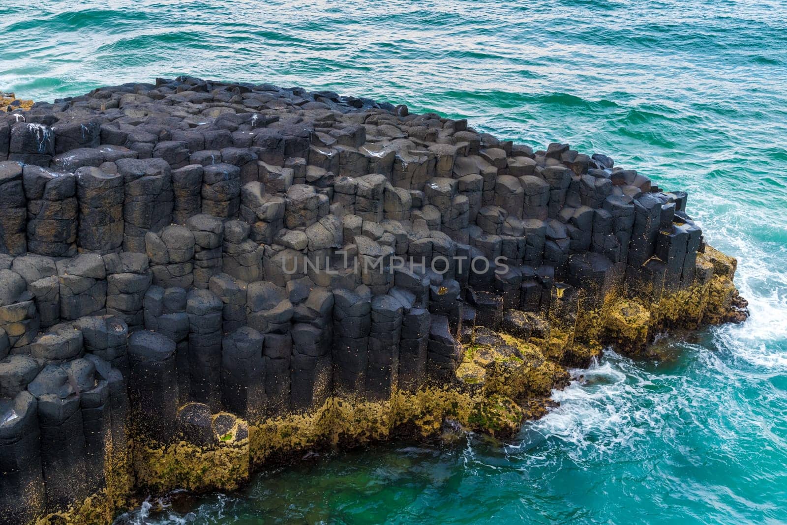 Crescent shaped hexagonal rock formations at Fingal Head, Australia