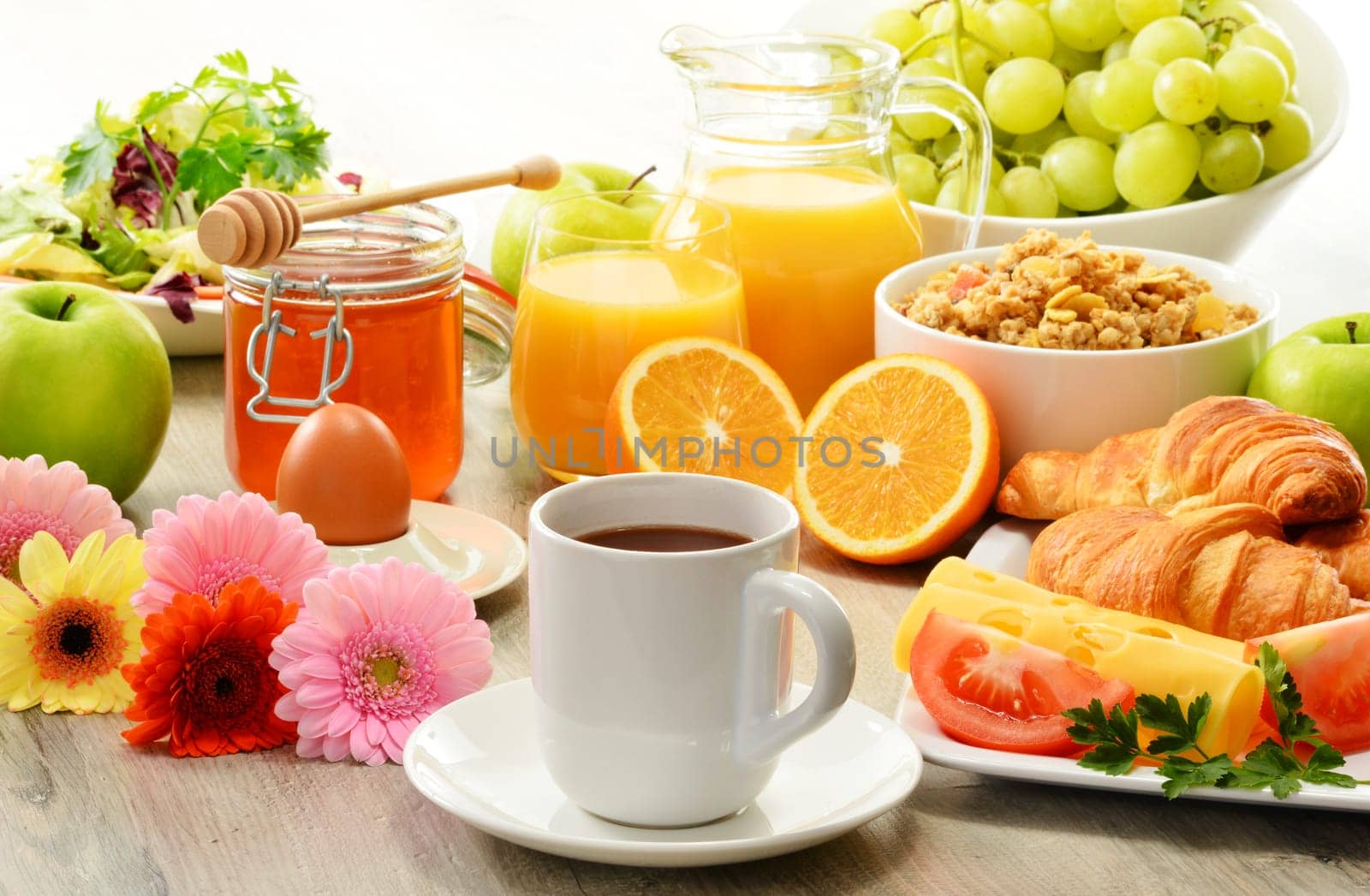 Breakfast consisting of fruits, orange juice, coffee, honey, bread and egg. Balanced diet