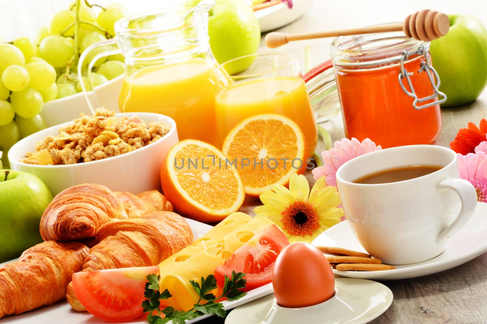 Breakfast consisting of fruits, orange juice, coffee, honey, bread and egg. Balanced diet