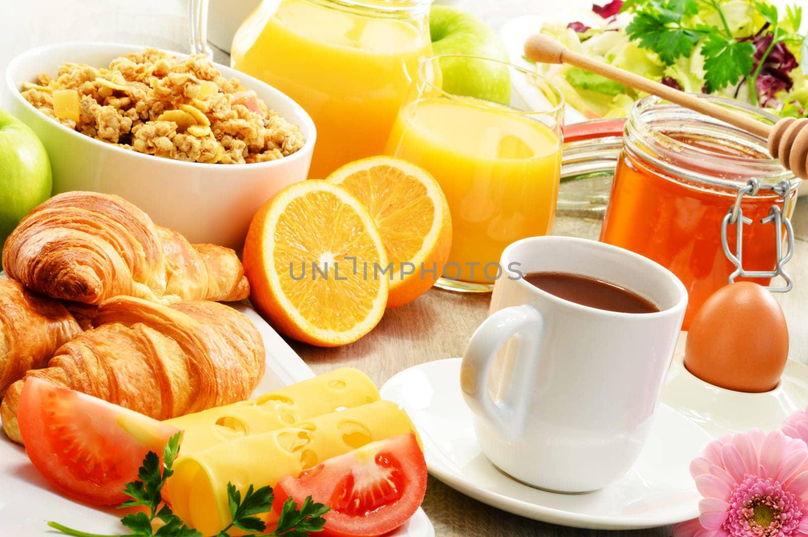 Breakfast consisting of fruits, orange juice, coffee, honey, bread and egg. Balanced diet