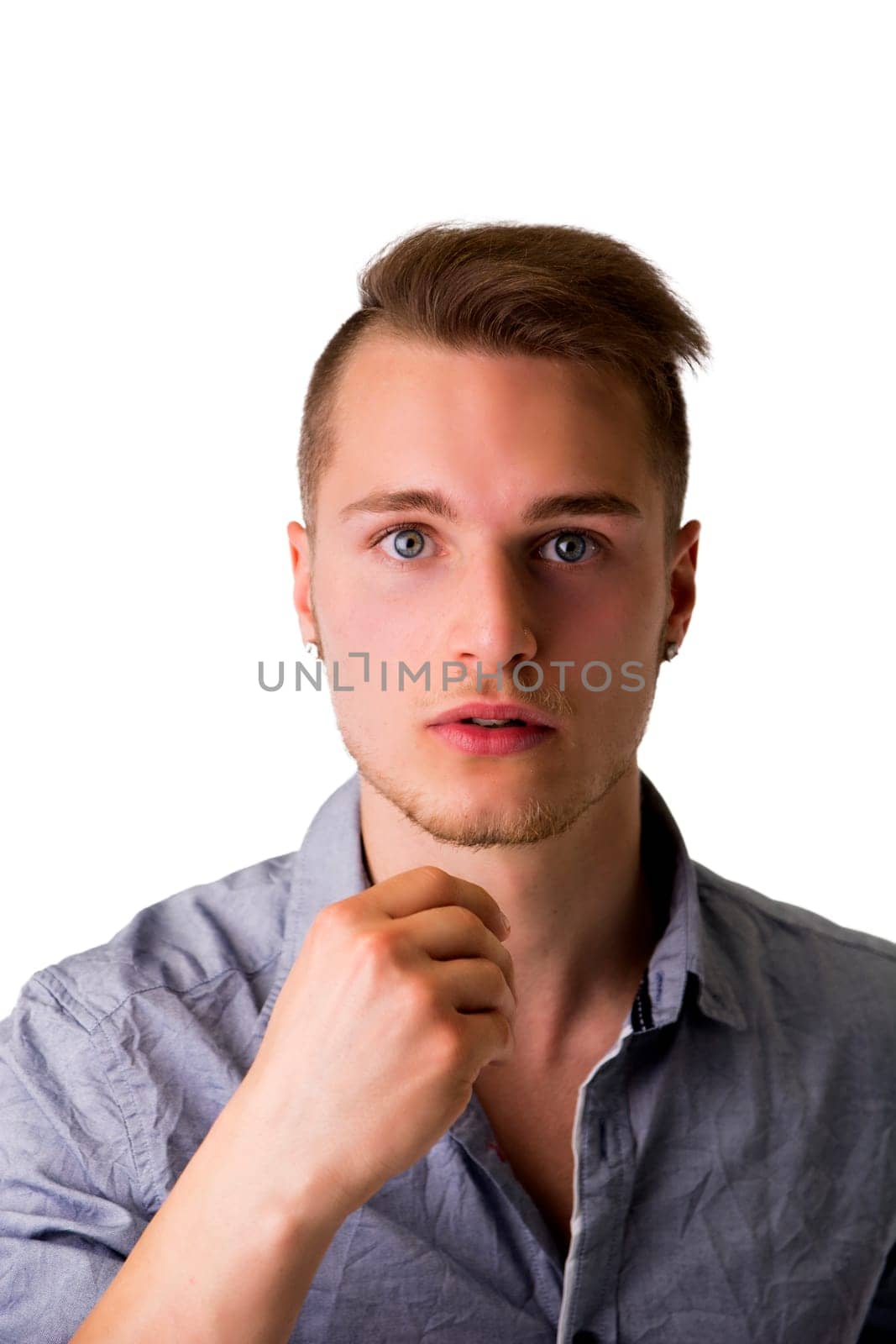 Handsome young man with aggressive, challenging expression, isolated on white