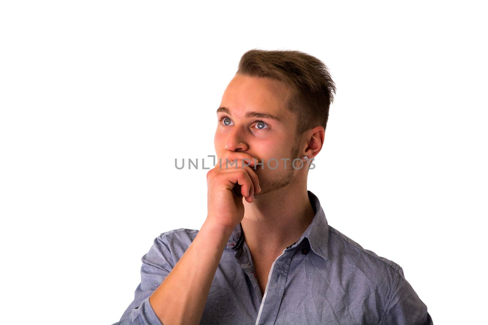 Dubious, unsure handsome blond young man isolated on white