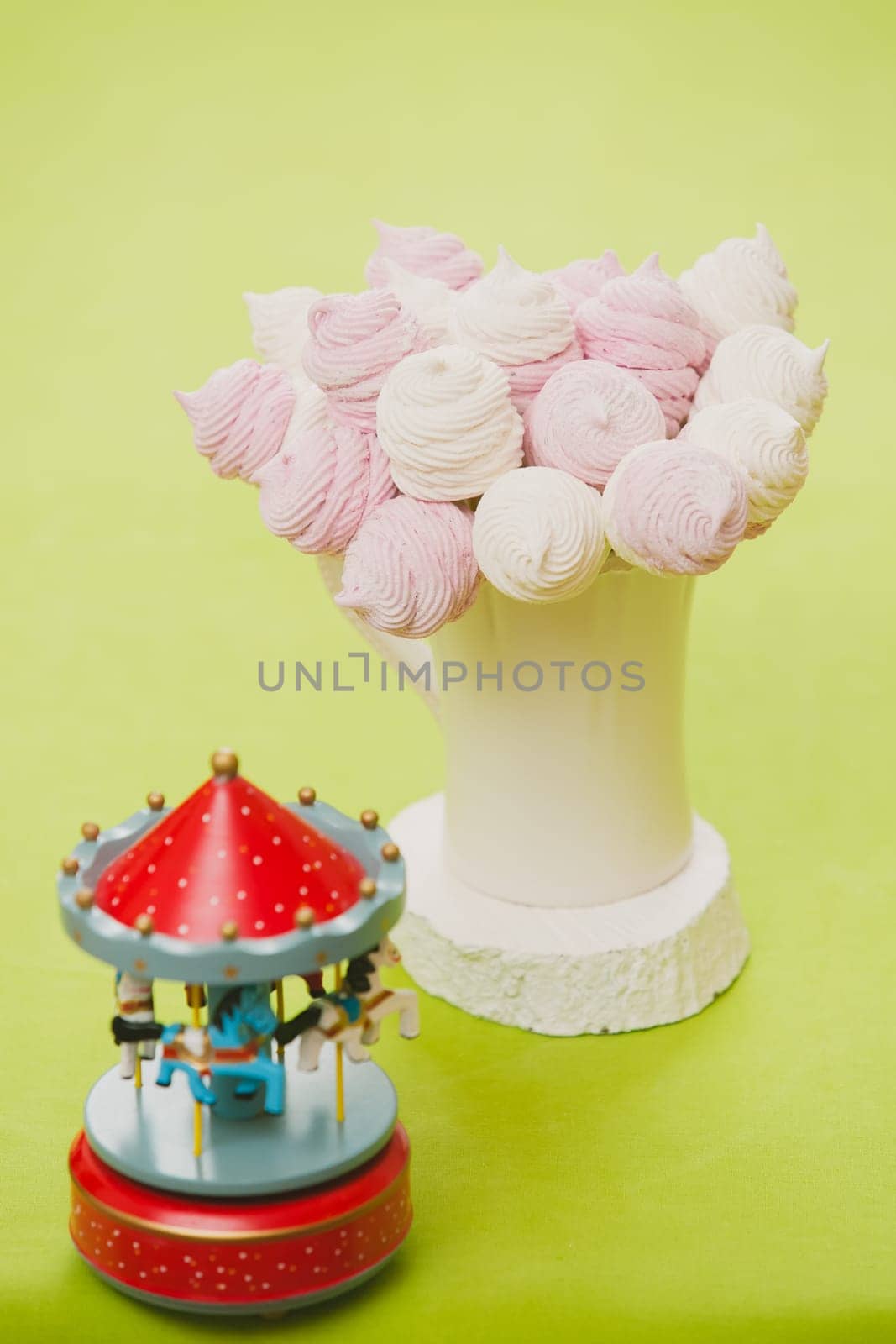 Delicious sweet buffet with homemade pink and white zephyr. Russian marshmallows. On a green background, selective focus