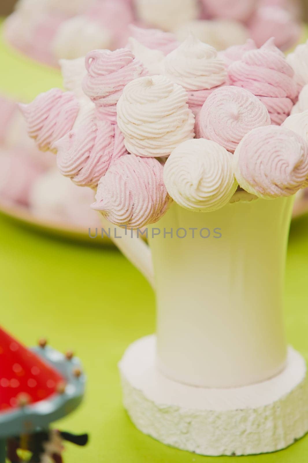 Delicious sweet buffet with homemade pink and white zephyr. Russian marshmallows. On a green background, selective focus