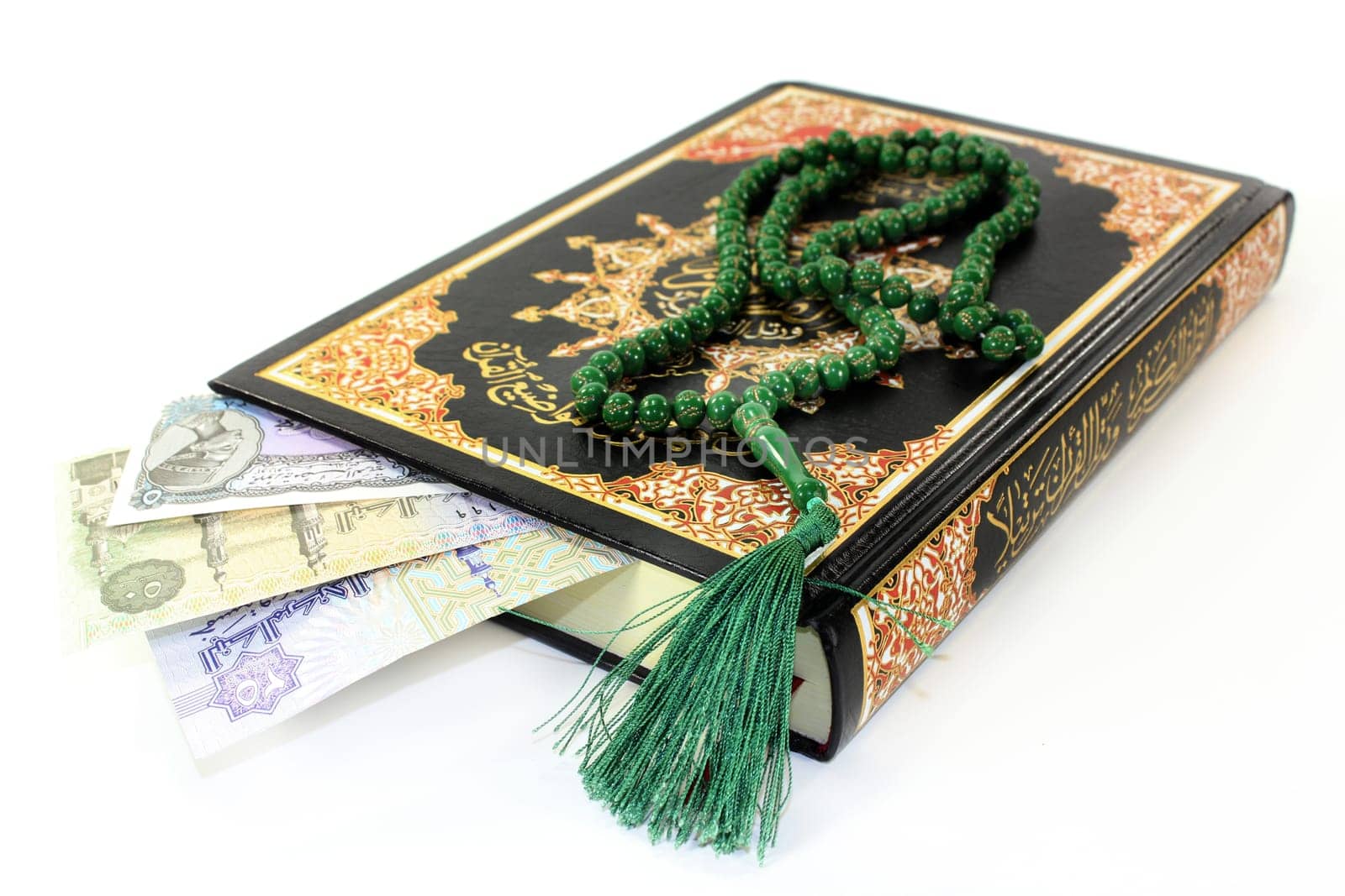 Quran with Egyptian banknotes against a white background