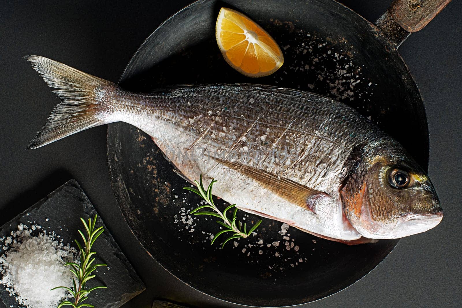 Delicious fresh fish on dark vintage background. Healthy food diet or cooking concept