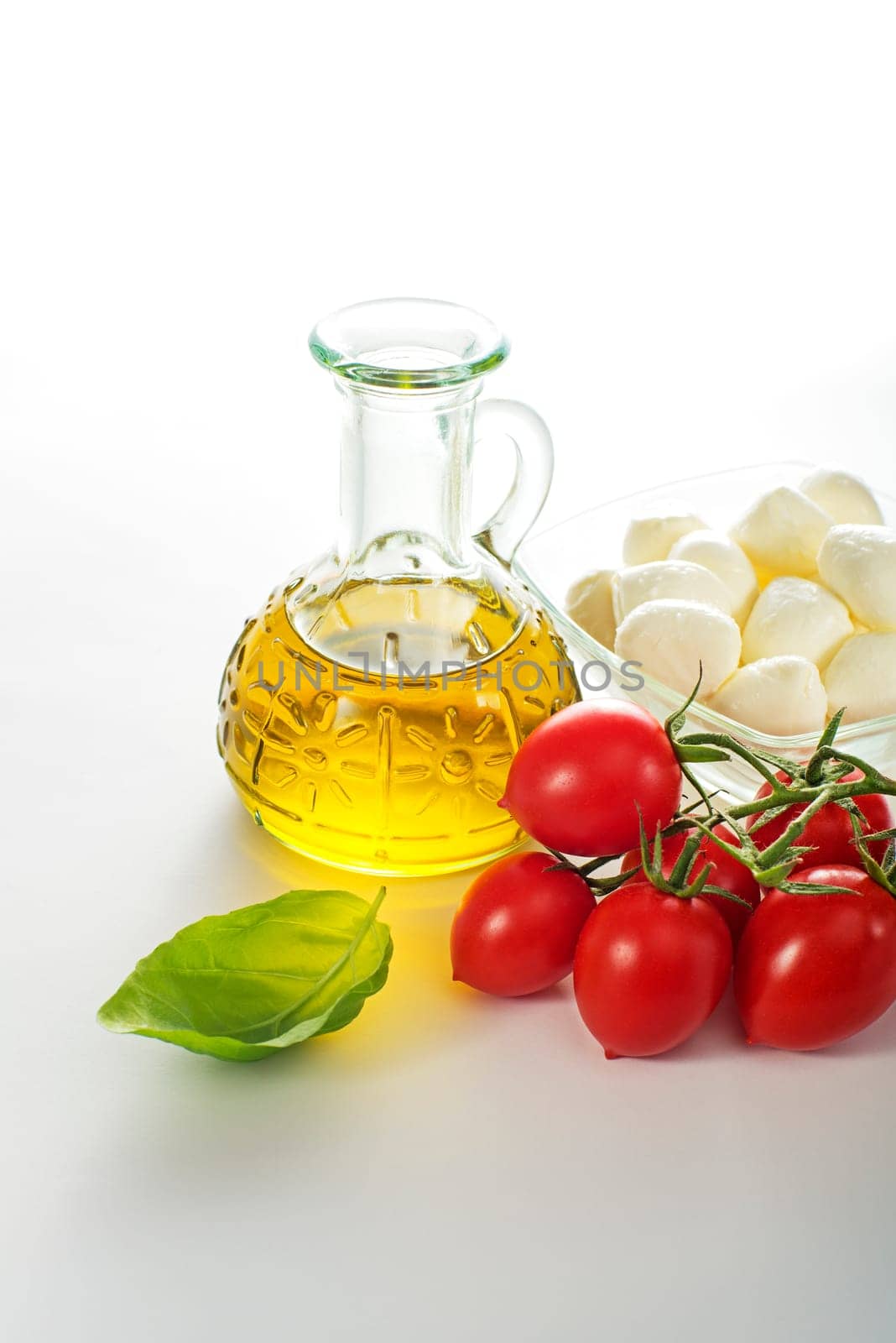 Fresh mozzarella cheese with tomato, basil and olive oil on white background