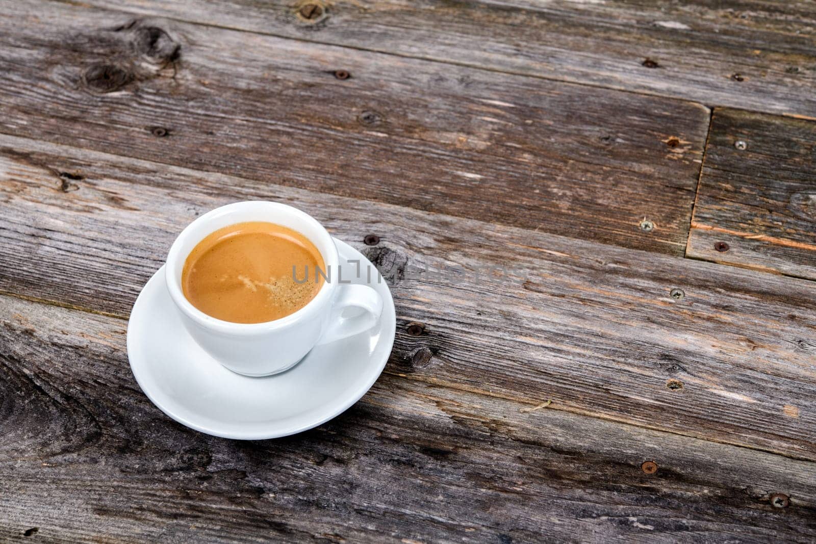 cup of coffee on wooden table from above