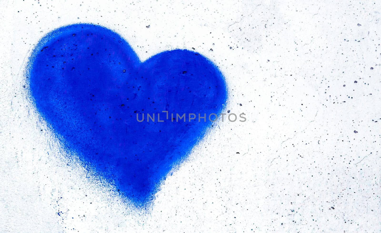 Blue heart shaped on grungy wall background with copy space