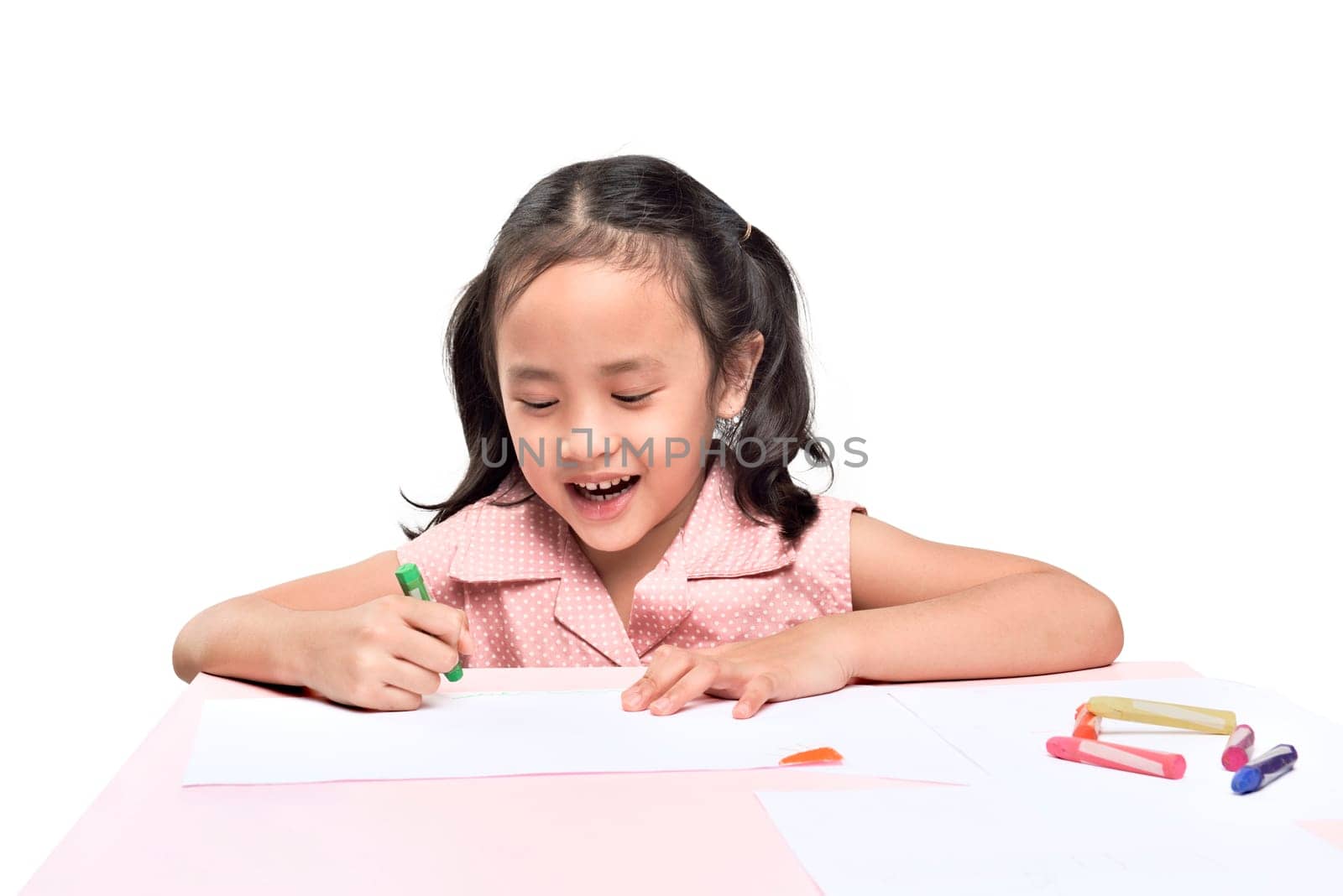 Portrait of asian little girl drawing with colorful crayon isolated over white background