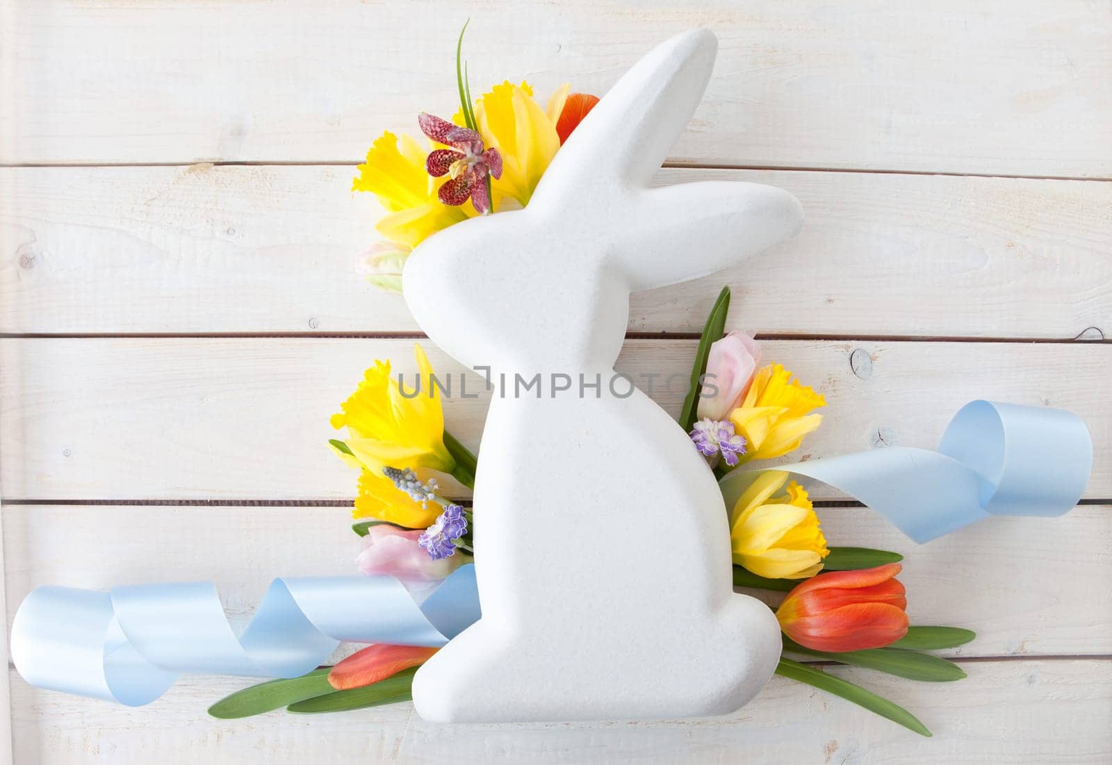 Easter bunny with fresh flowers in Spring
