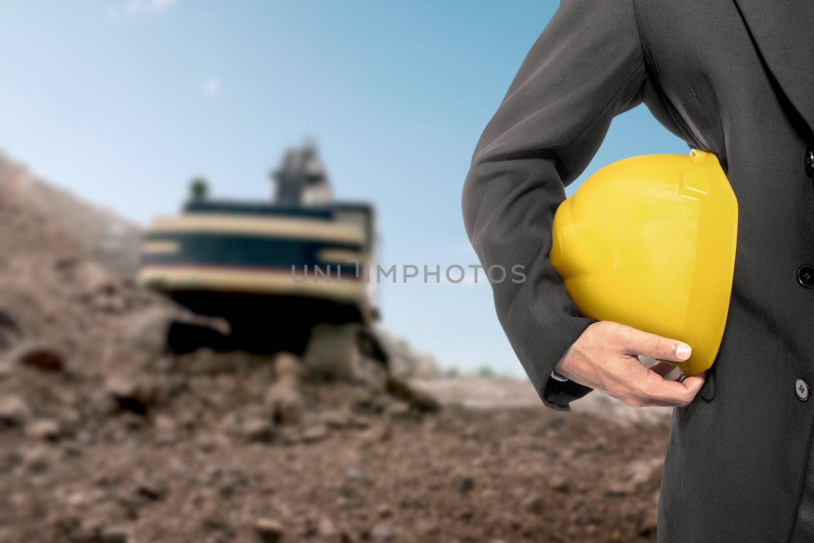 Contractor man holding a yellow helmet on construction site