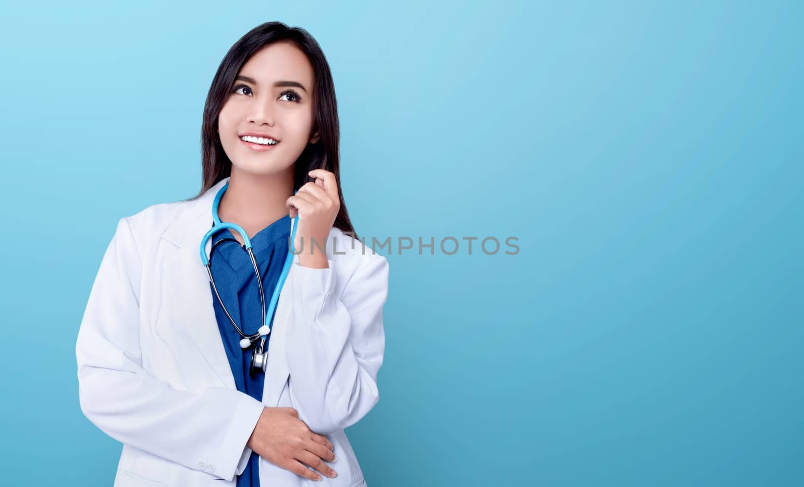 Young asian doctor woman in white coat and stethoscope over blue bright background