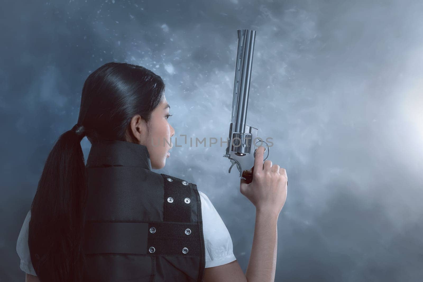 Back view of asian woman with police uniform holding guns on dark background
