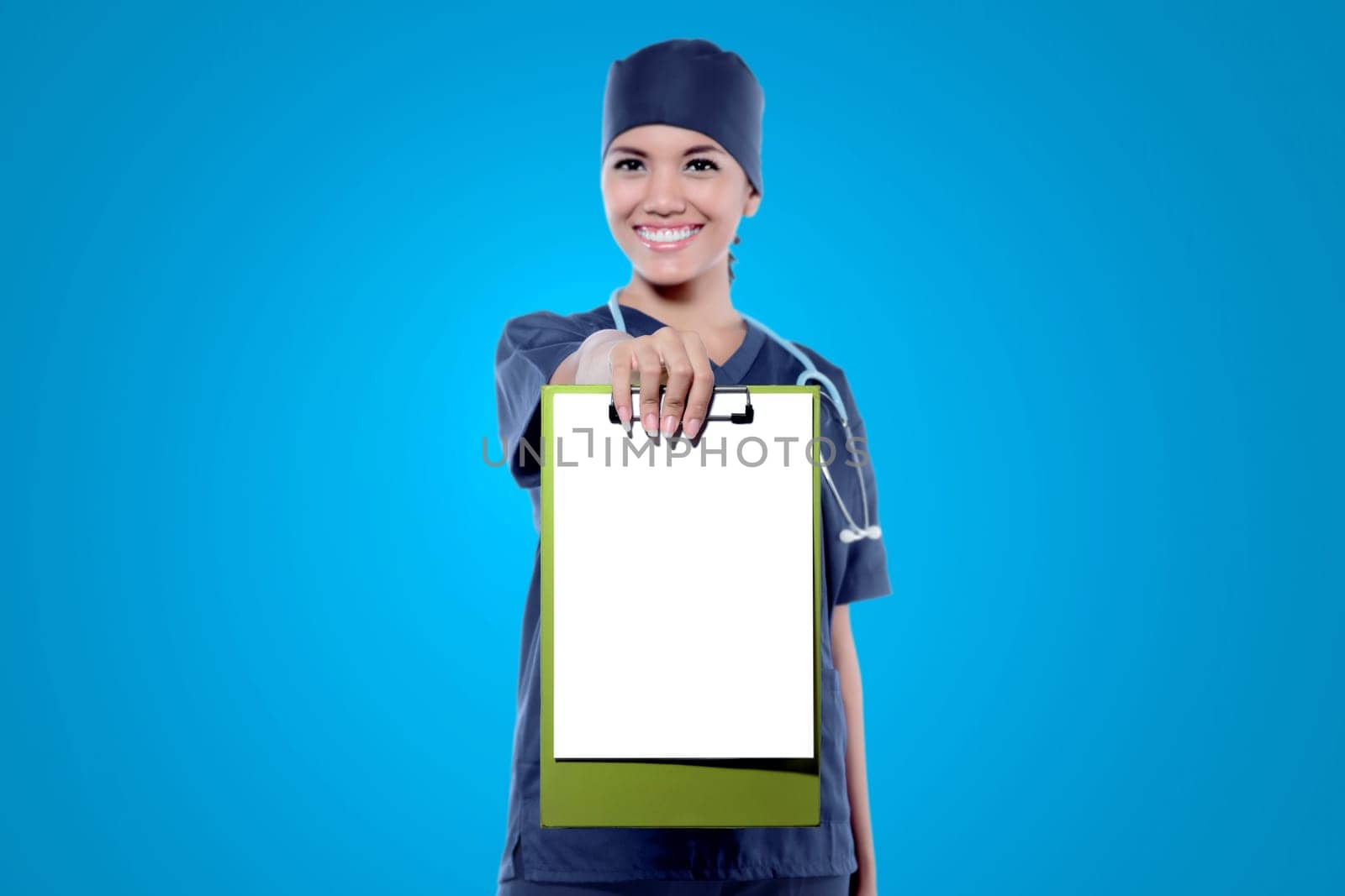 Young asian female doctor showing her empty clipboard for copyspace over blue background