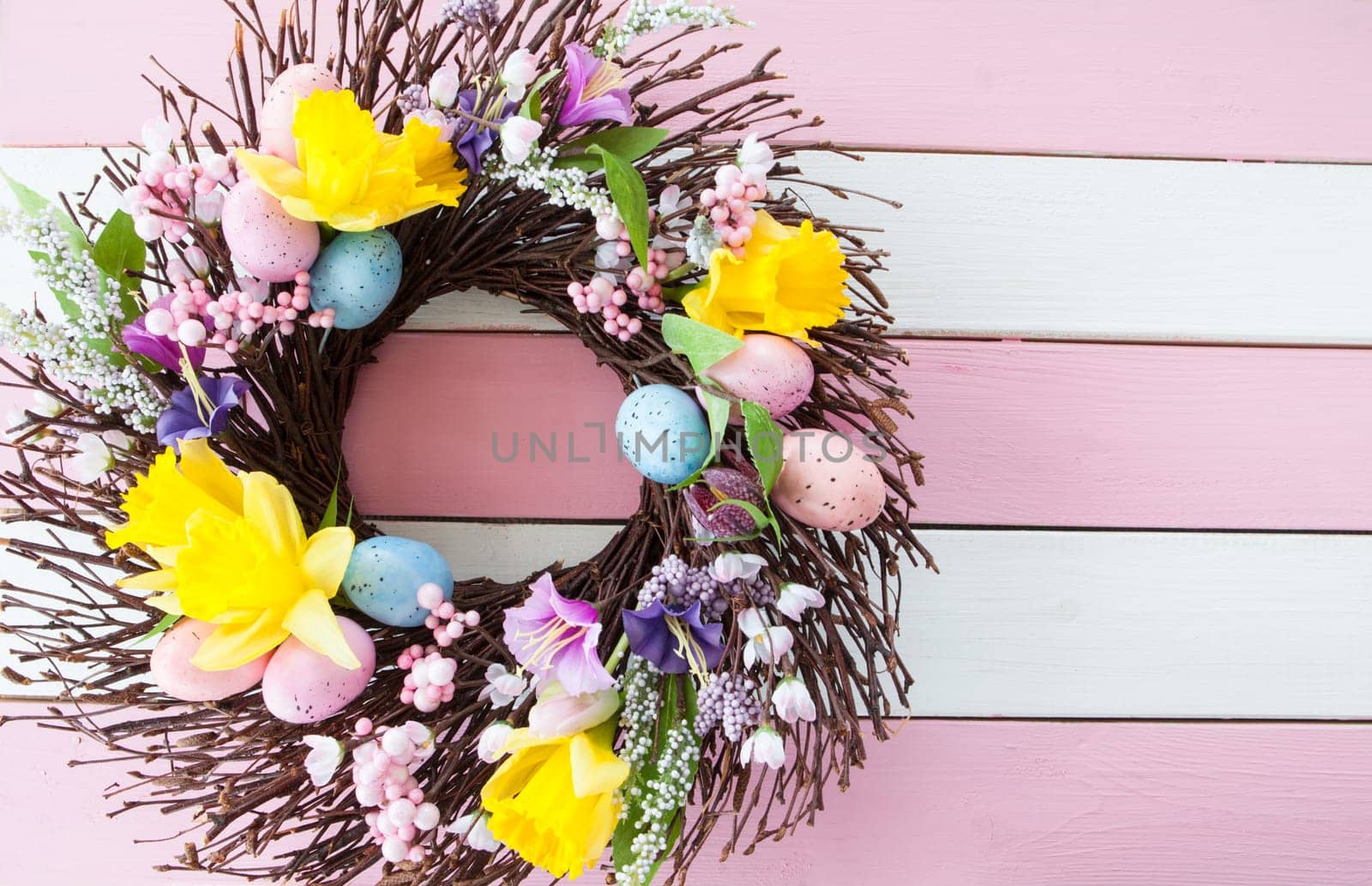 Colorful wreath with Easter eggs and flowers for Easter