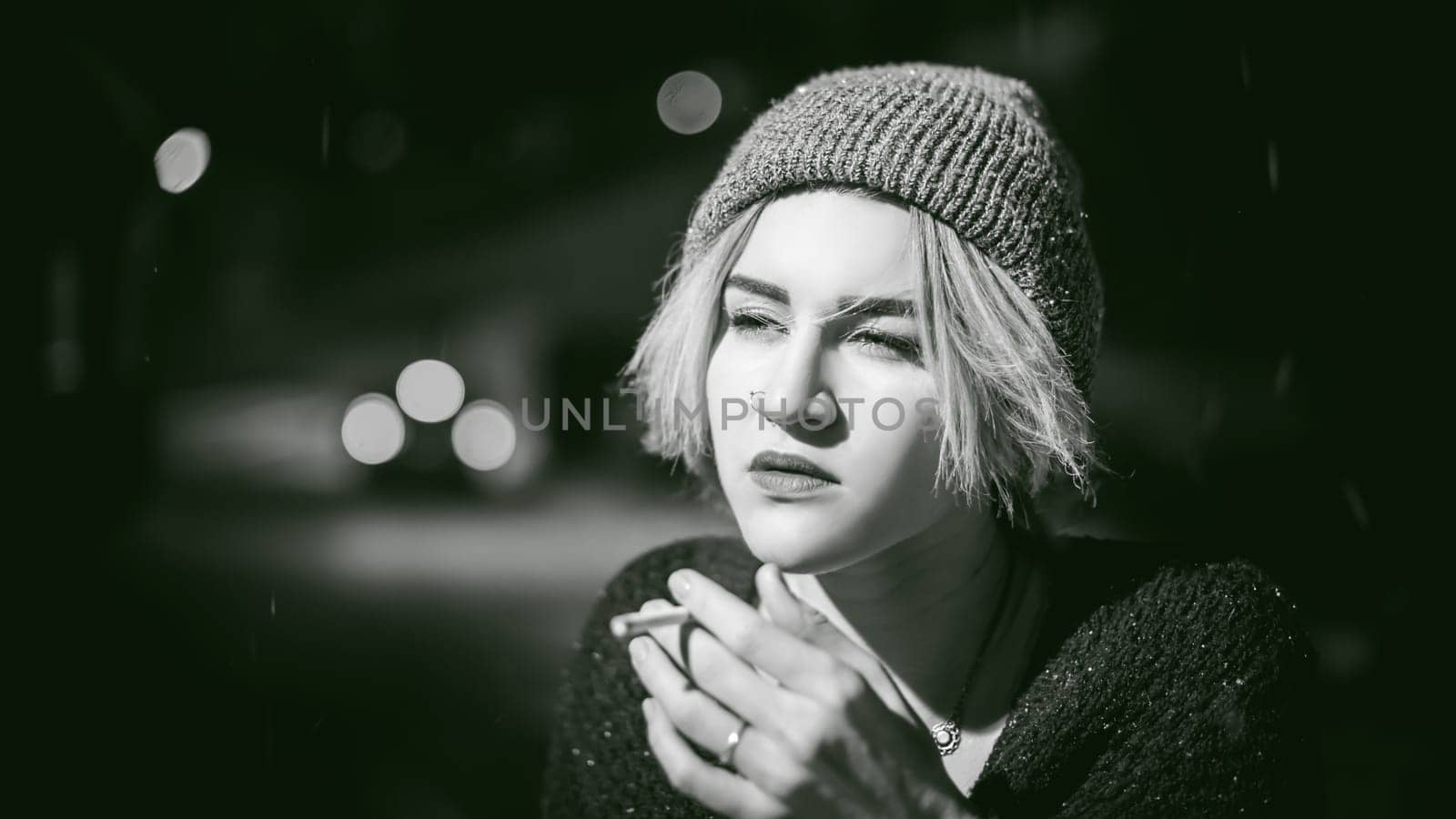 Portrait of a girl with a cigarette. young beautiful girl with dyed hair hipster hat. cigarette smoking on the street under the snow