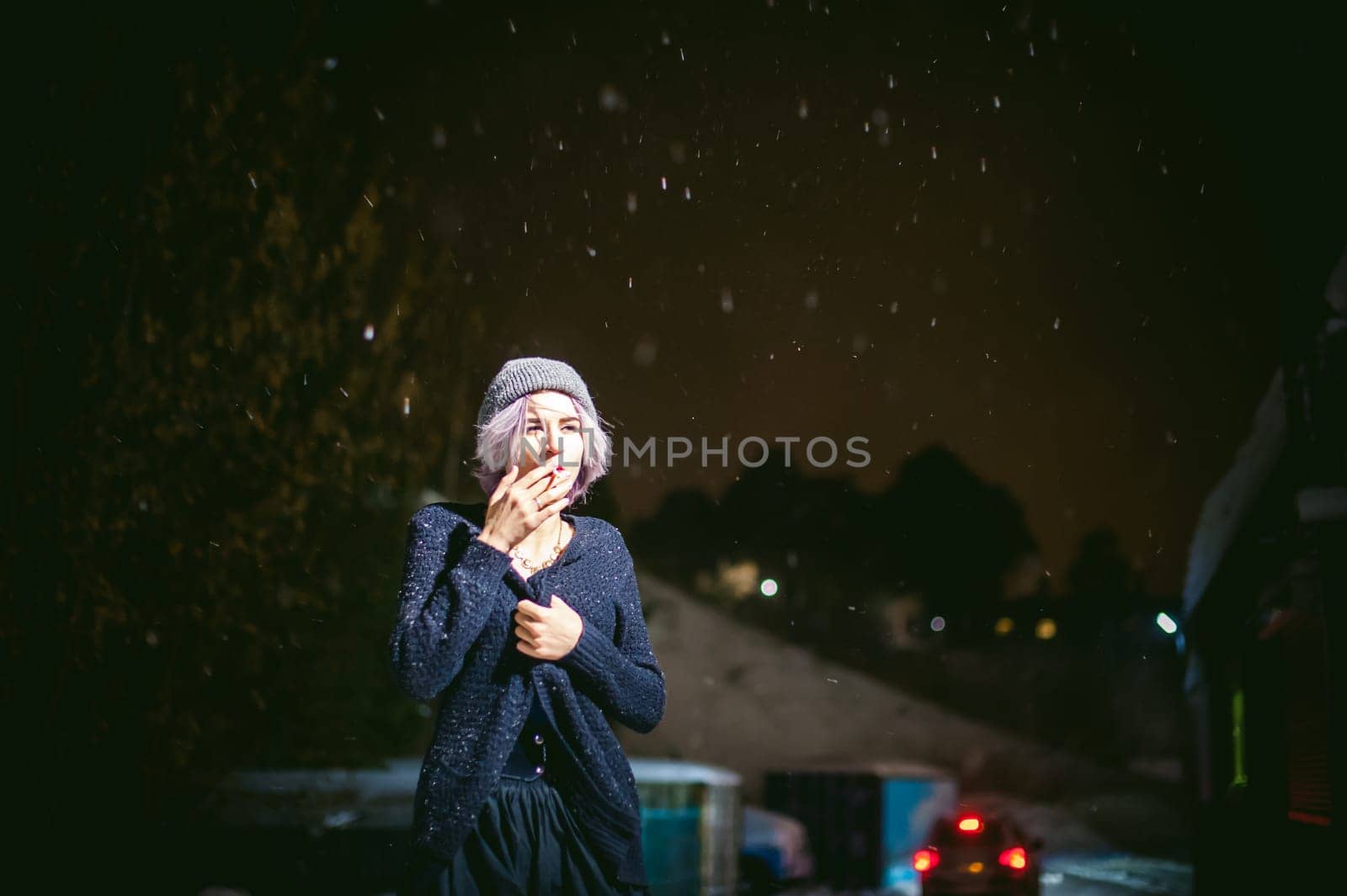 Portrait of a girl with a cigarette. young beautiful girl with dyed hair hipster hat. cigarette smoking on the street under the snow
