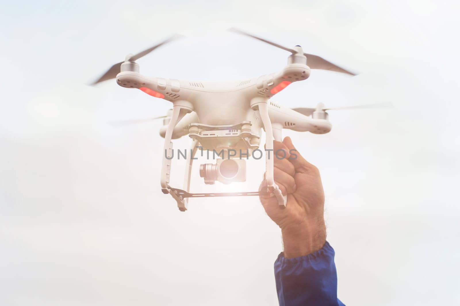 The flying drone copter with digital camera and human hand