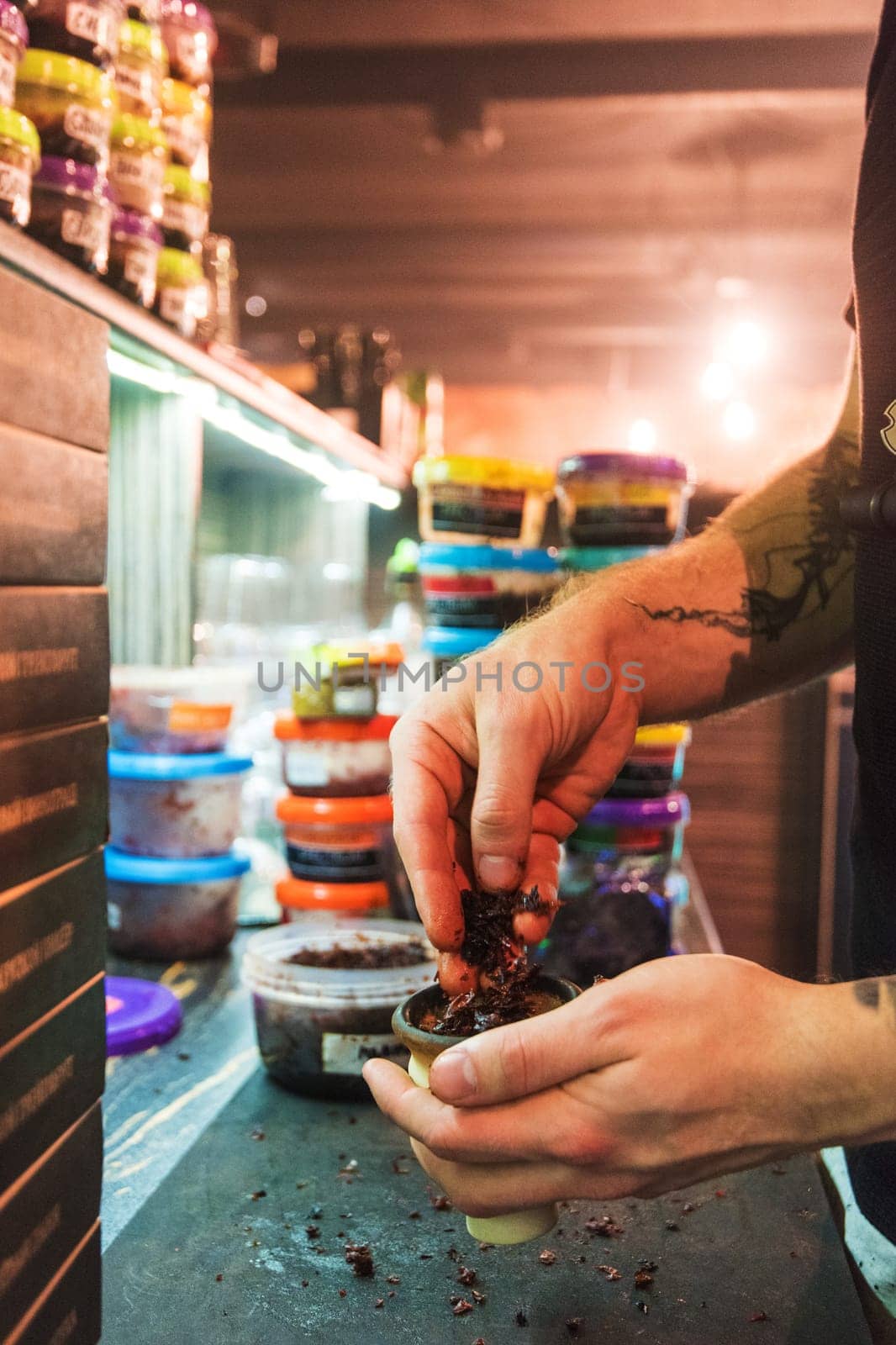 Shisha hookah preparing by barman. Bartender lays tobacco for smoking in hookah