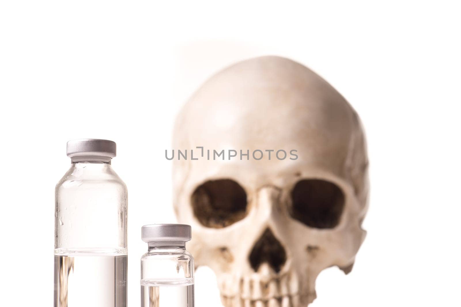 Medical vials with clear liquid and blurry skull isolated on white background